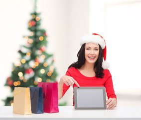 woman in santa helper hat with tablet pc