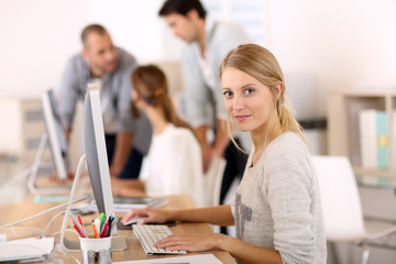 Young girl in office working on desktop computer