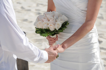 wedding couple holding hands on the beach
