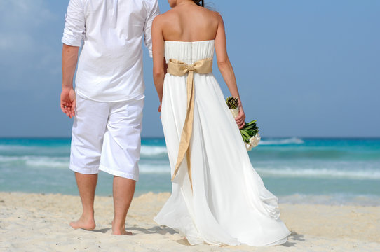 wedding couple walking away on the beach
