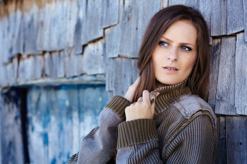 Fototapeta premium Beautiful woman leaning on a cabin log