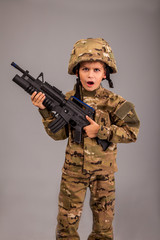 Young boy dressed like a soldier with rifle