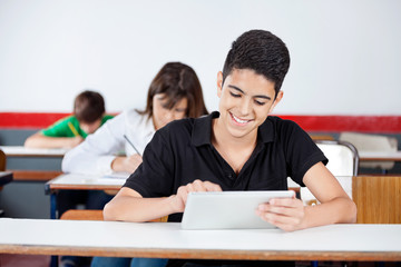 Teenage Schoolboy Using Digital Tablet At Desk