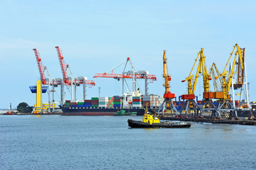 Obraz premium Container stack and ship under crane bridge