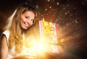 A young and happy teenage girl opening the present