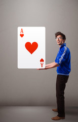 Young man holding a red heart ace