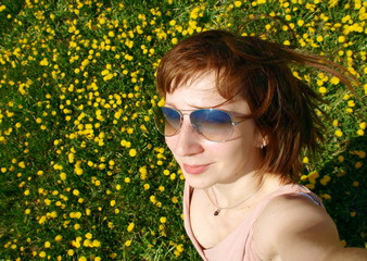 Self-portrait of a smiling girl on dungelion field