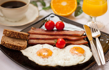 eggs and bacon, tomato, orange juice and coffee for breakfast
