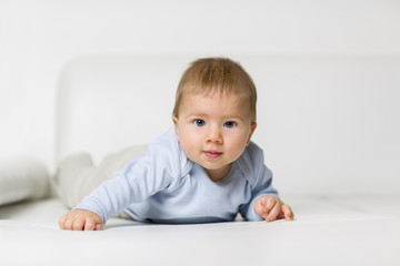 Fototapeta premium Portrait of cute baby boy lying on belly.