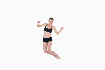 Fototapeta na wymiar Full length of a sporty young woman jumping