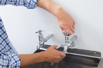 Close up of a plumber's hand and washbasin