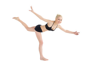 Fototapeta premium Sporty young woman balancing on one leg