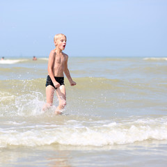 Fototapeta premium Happy teenager boy plays on the beach