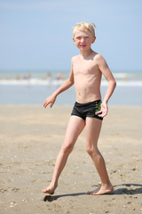 Happy teenager boy plays on the beach © cromary