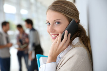 Young woman in school campus using smartphone