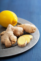 fresh ginger root and lemon on vintage plate