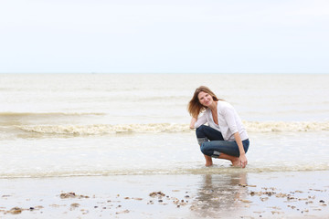 Fototapeta na wymiar Young beautiful slim woman relaxing on the beach