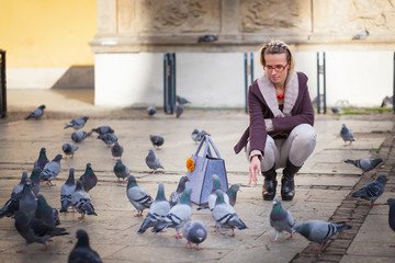 The girl feeds pigeons