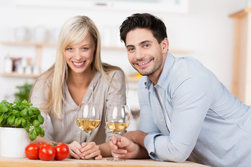 glückliches paar trinkt ein glas wein in der küche