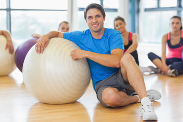 Naklejka premium Instructor and fitness class with exercise balls at gym