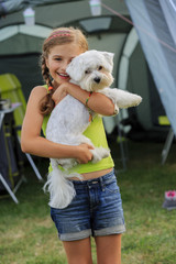 Camp in the tent - young girl playing with dog 