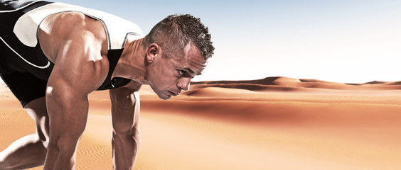 Extreme athlete runner man in starting position outdoor in deser