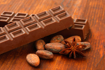 Delicious chocolate bars with cocoa beans close up