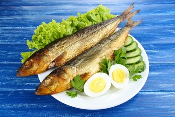 Smoked fish on plate on wooden table