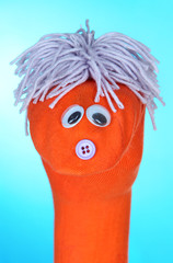 Cute sock puppet on blue background