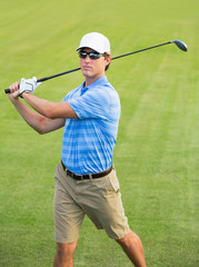 Athletic young man playing golf
