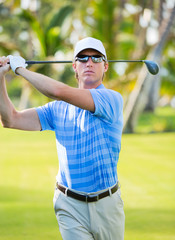 Athletic young man playing golf