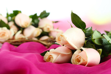 Beautiful bouquet of roses, on fabric, on light background