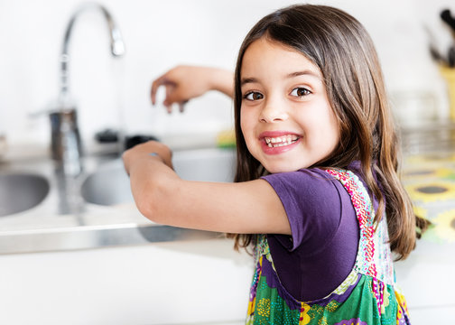 Expressive portrait of very cute girl washing hands