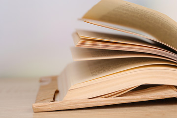 Opened book on wooden table on bright background