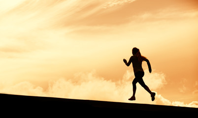 Fototapeta na wymiar Female runner silhouette, running into sunset