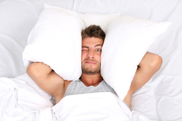 Handsome young man in bed