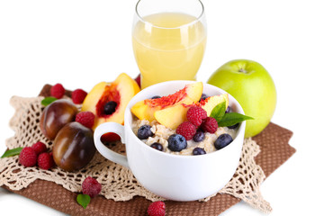 Oatmeal in cup with berries on napkins isolated on white