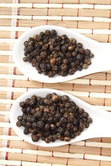black pepper on white ceramic spoon