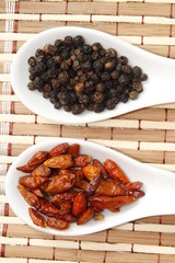 black pepper and chili on white ceramic spoon