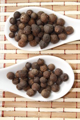 allspice on white ceramic spoon