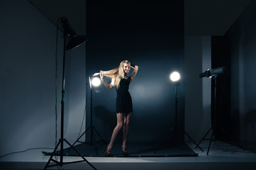 Obraz na płótnie Canvas Beautiful woman posing at studio in light flashes
