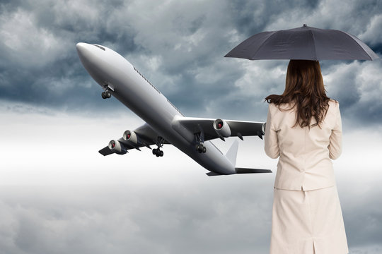 Composite image of rear view of classy businesswoman holding umb