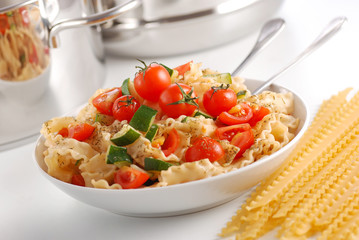 pasta con pomodorini e zucchine sul tavolo bianco