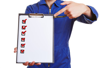 Arbeiter im Blaumann zeigt auf Checkliste