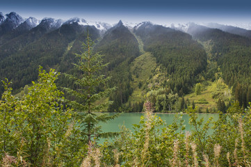 Duffey lake beneath snow-capped misty mountains