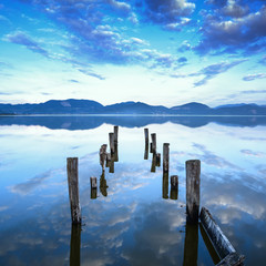 Obrazy  Drewniane molo lub molo pozostaje na zachód słońca nad jeziorem. Toskania, Włochy