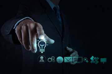 businessman hand draws lightbulb with new computer interface as