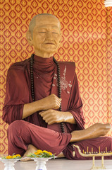 wax figure of Buddhist monk in meditation sitting position