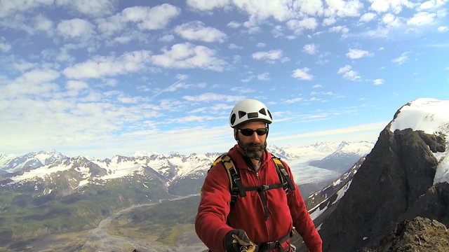 Peak Mountain climber filming glacier project, Alaska, USA 