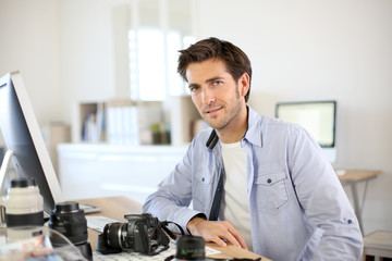 Photographer in office working on desktop computer